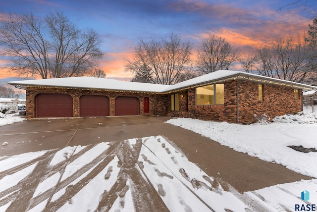 view of front facade featuring brick siding, a garage, and driveway