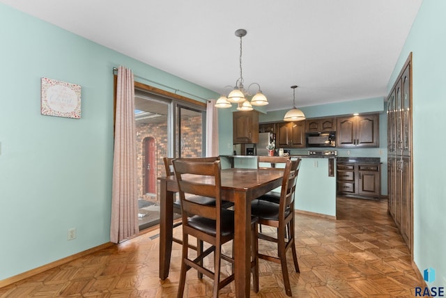 dining room with an inviting chandelier and baseboards