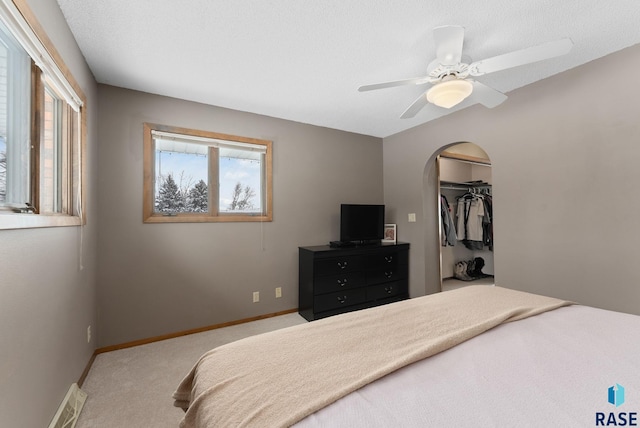 bedroom featuring visible vents, a ceiling fan, a textured ceiling, carpet floors, and baseboards