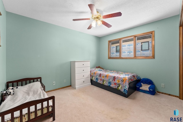 carpeted bedroom with baseboards, a textured ceiling, and ceiling fan