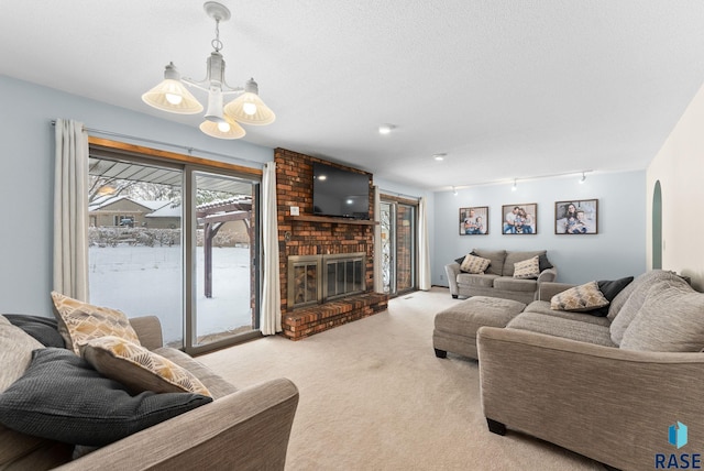 living area with light carpet, a textured ceiling, arched walkways, an inviting chandelier, and a brick fireplace