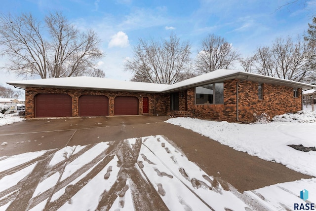 view of front of house featuring brick siding, driveway, and a garage