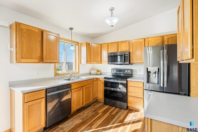 kitchen with a sink, stainless steel appliances, vaulted ceiling, and light countertops