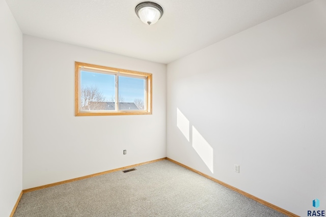 spare room with visible vents, baseboards, and carpet