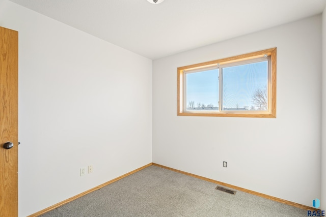 empty room featuring visible vents, baseboards, and carpet flooring