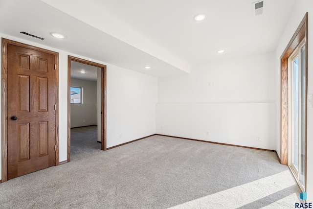 unfurnished room featuring light colored carpet, visible vents, and baseboards