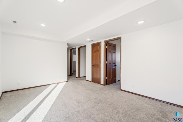 empty room featuring recessed lighting, baseboards, and light colored carpet