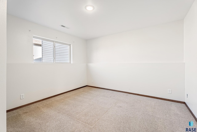 carpeted empty room featuring baseboards and visible vents