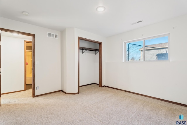 unfurnished bedroom with visible vents, light carpet, and a closet