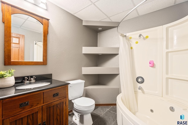 full bathroom with tile patterned flooring, a drop ceiling, shower / bath combo with shower curtain, toilet, and vanity