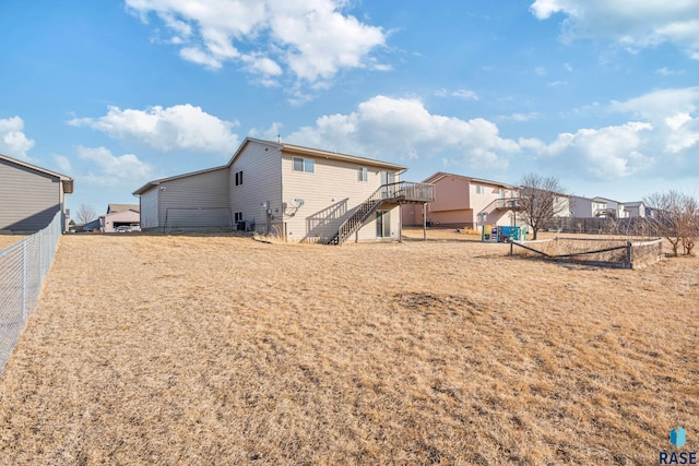 back of property featuring a residential view, stairs, and fence