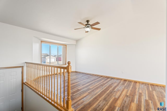 empty room with a ceiling fan, baseboards, and wood finished floors