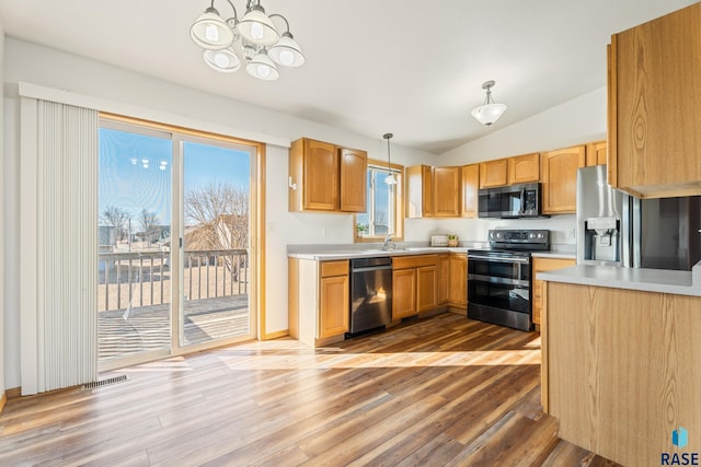 kitchen with lofted ceiling, appliances with stainless steel finishes, light wood-style flooring, and light countertops