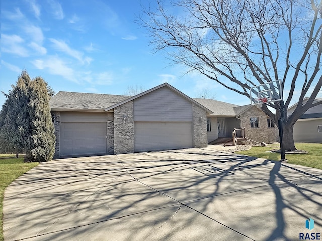 view of front of property with concrete driveway, brick siding, a garage, and a front lawn