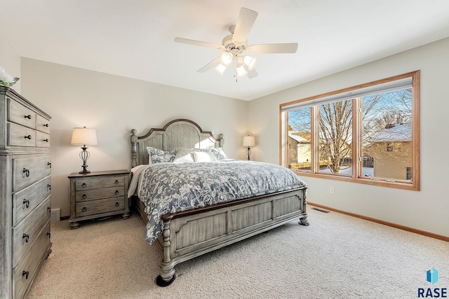 bedroom featuring visible vents, light colored carpet, baseboards, and ceiling fan