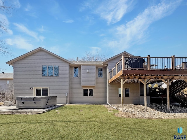 back of property with a deck, a yard, a patio area, and a hot tub