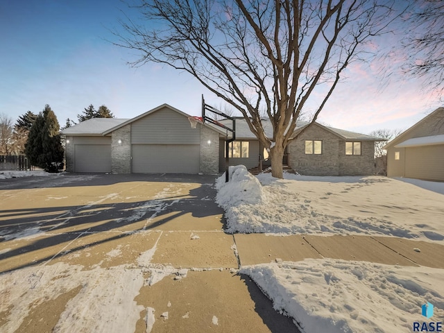 view of front of house with an outbuilding, brick siding, a garage, and driveway