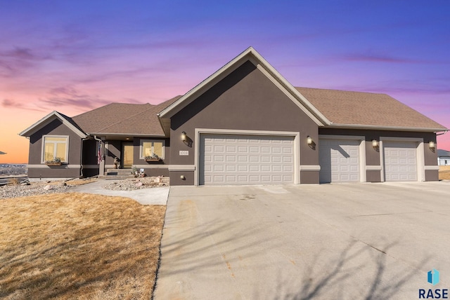 ranch-style home with stucco siding, driveway, and an attached garage