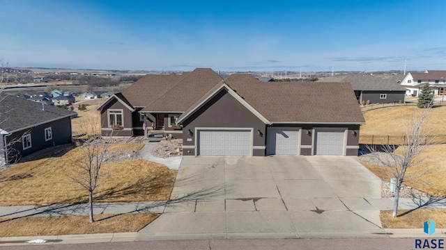 view of front of home with concrete driveway, an attached garage, fence, and stucco siding