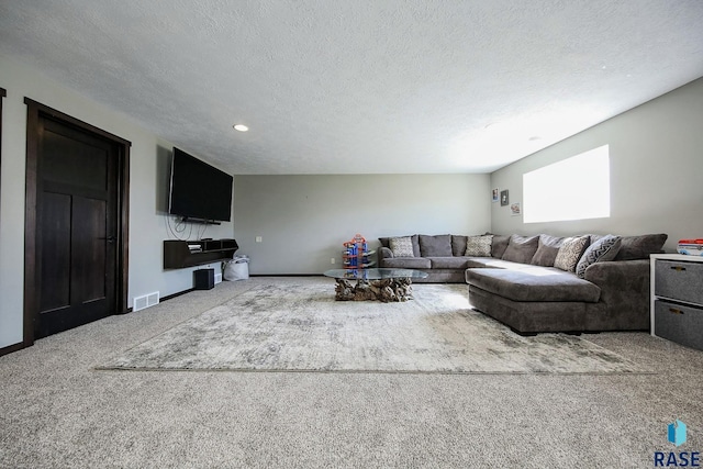 carpeted living area featuring visible vents, a textured ceiling, and baseboards