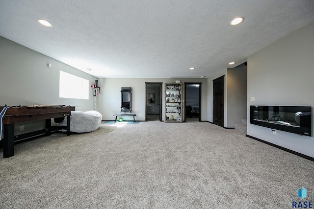 living area with recessed lighting, baseboards, a textured ceiling, and carpet flooring