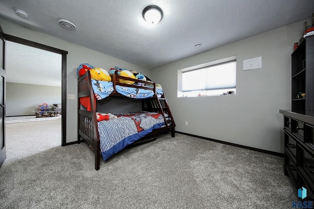 bedroom featuring baseboards, carpet flooring, a textured ceiling, and visible vents