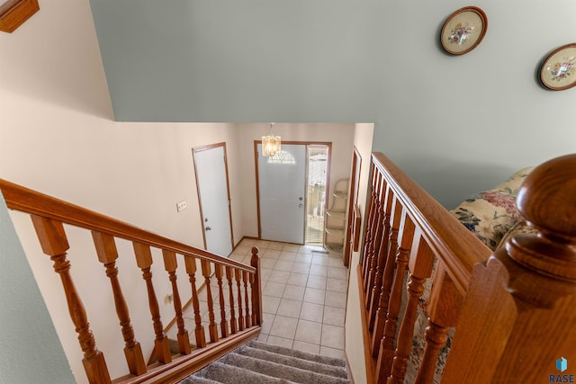 foyer entrance featuring stairs, a notable chandelier, and light tile patterned floors