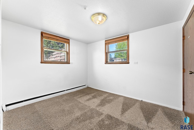 carpeted empty room with a baseboard heating unit and a textured ceiling