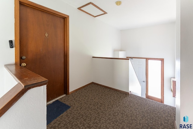 hall featuring baseboards and carpet floors