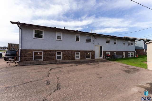 view of front of property featuring stucco siding and brick siding