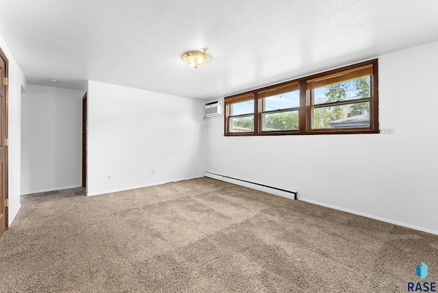 empty room with a baseboard heating unit, a wall unit AC, carpet flooring, and a textured ceiling