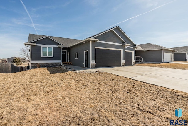 ranch-style home featuring driveway, an attached garage, and fence