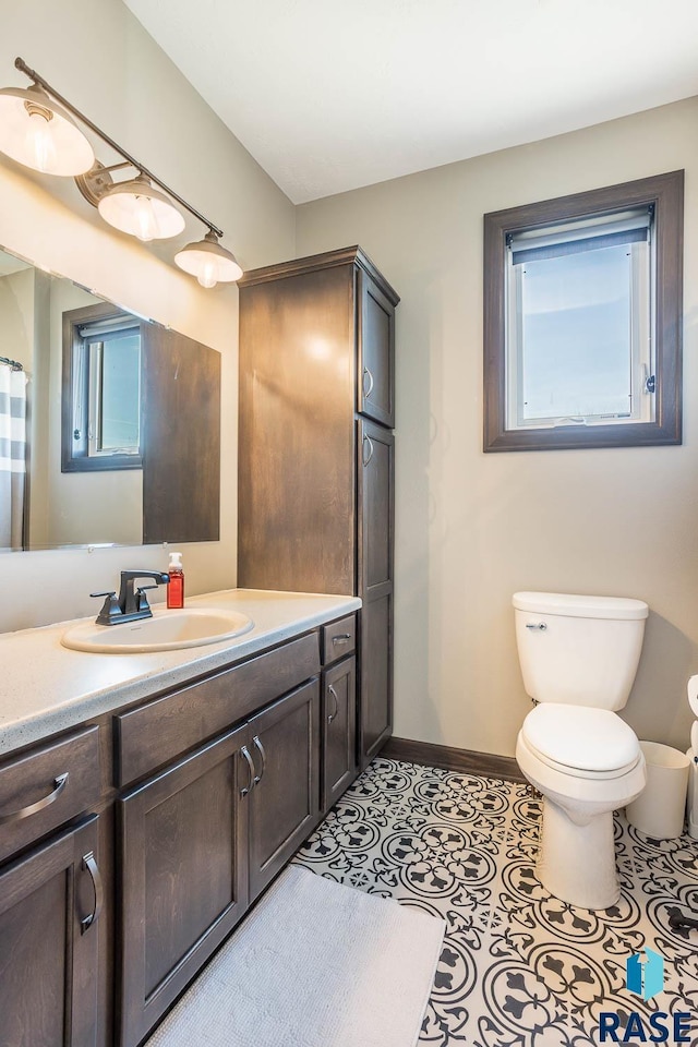 bathroom featuring tile patterned floors, toilet, vanity, and baseboards