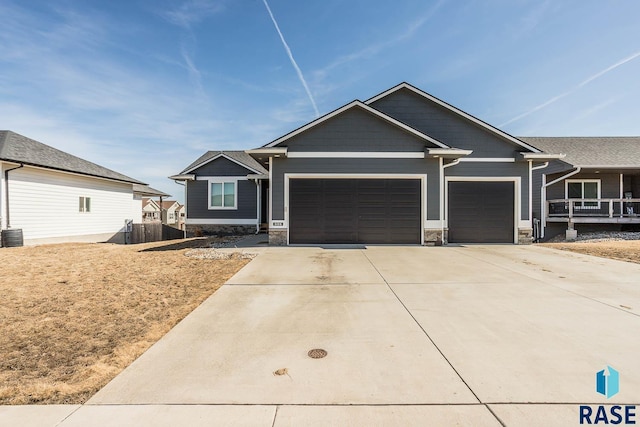 craftsman house featuring stone siding, driveway, and a garage