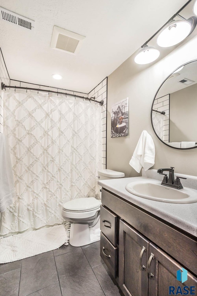 full bathroom with tile patterned floors, visible vents, toilet, and vanity