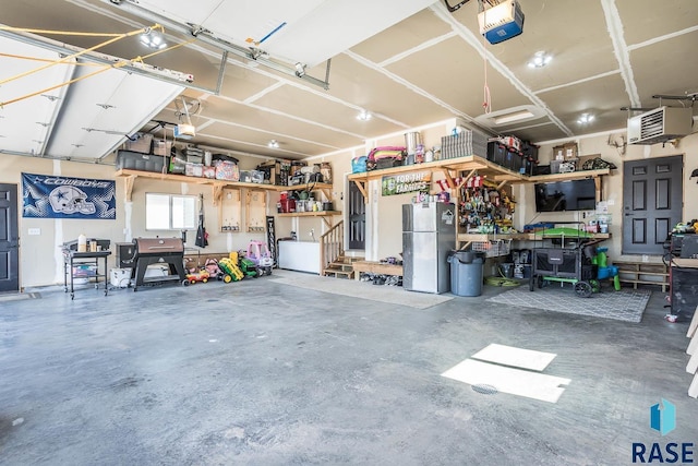 garage featuring a workshop area, a garage door opener, and freestanding refrigerator