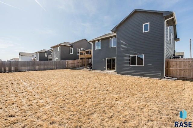 rear view of house with a fenced backyard