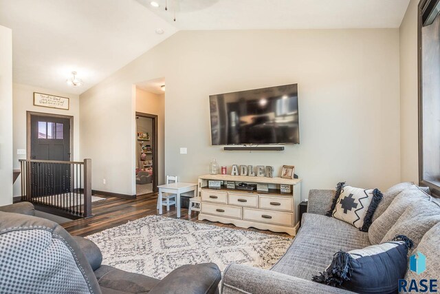 living area with baseboards, lofted ceiling, and dark wood-style flooring