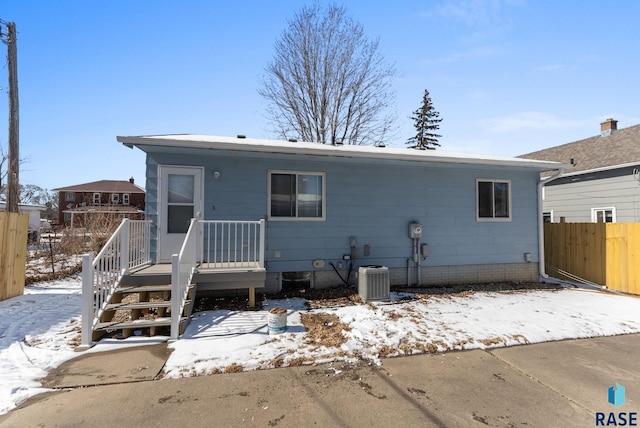 view of front of house with fence and central AC