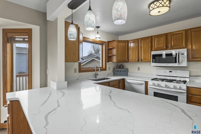 kitchen featuring a sink, white appliances, and brown cabinets