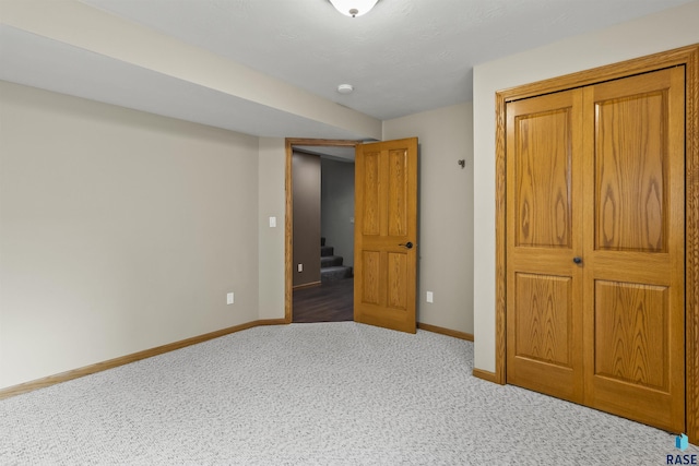 unfurnished bedroom with a closet, baseboards, and carpet floors