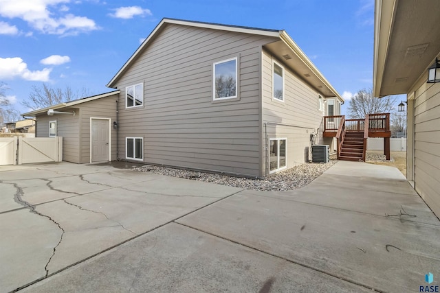 back of house with stairway, a gate, fence, a wooden deck, and central air condition unit