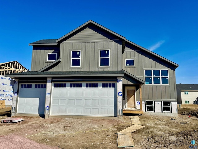 view of front of house with board and batten siding, driveway, and a shingled roof