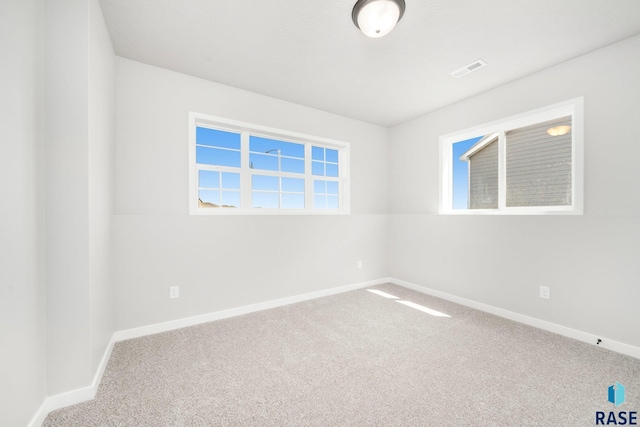 unfurnished room featuring visible vents, carpet floors, and baseboards