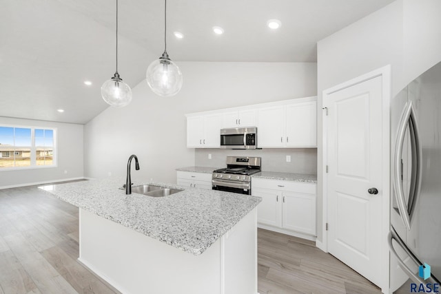 kitchen featuring light wood-style flooring, an island with sink, a sink, stainless steel appliances, and white cabinets