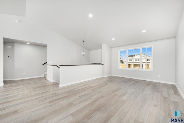 spare room with recessed lighting, baseboards, light wood-style flooring, and vaulted ceiling