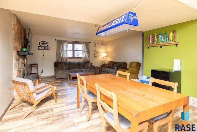 dining space featuring visible vents and wood finished floors