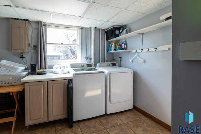 laundry room featuring cabinet space, washer and dryer, tile patterned floors, and baseboards