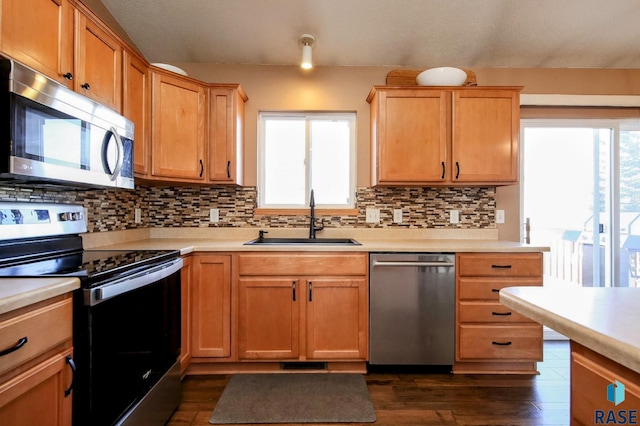 kitchen featuring light countertops, a wealth of natural light, appliances with stainless steel finishes, and a sink