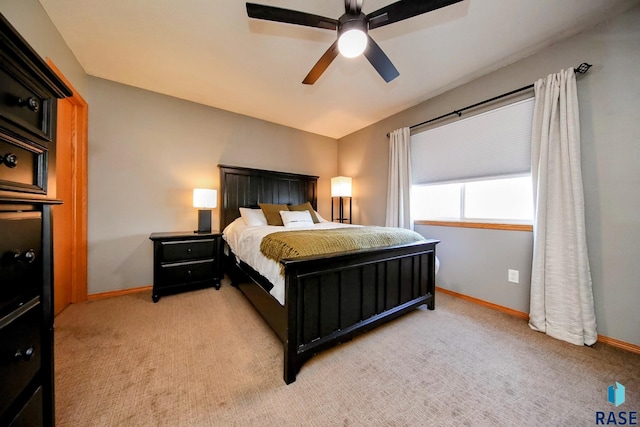 bedroom featuring a ceiling fan, light colored carpet, and baseboards